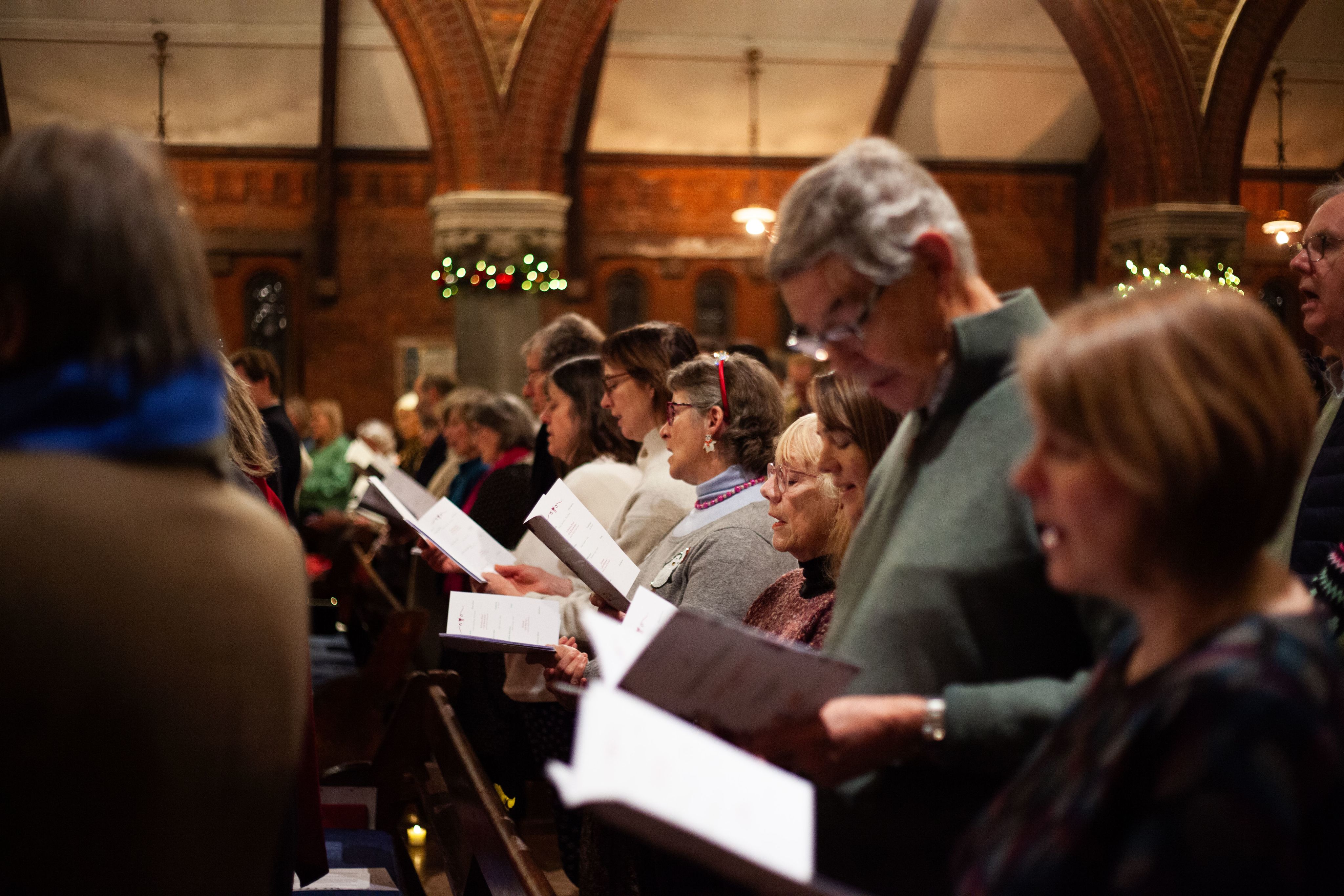 Carol singers sing in a church during the Celestial Christmas 2024 concert.