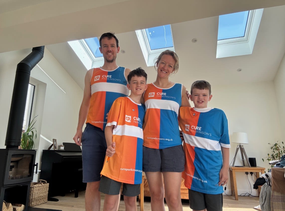 A family of fundraisers stand in their house in Cure Parkinson's t-shirts.