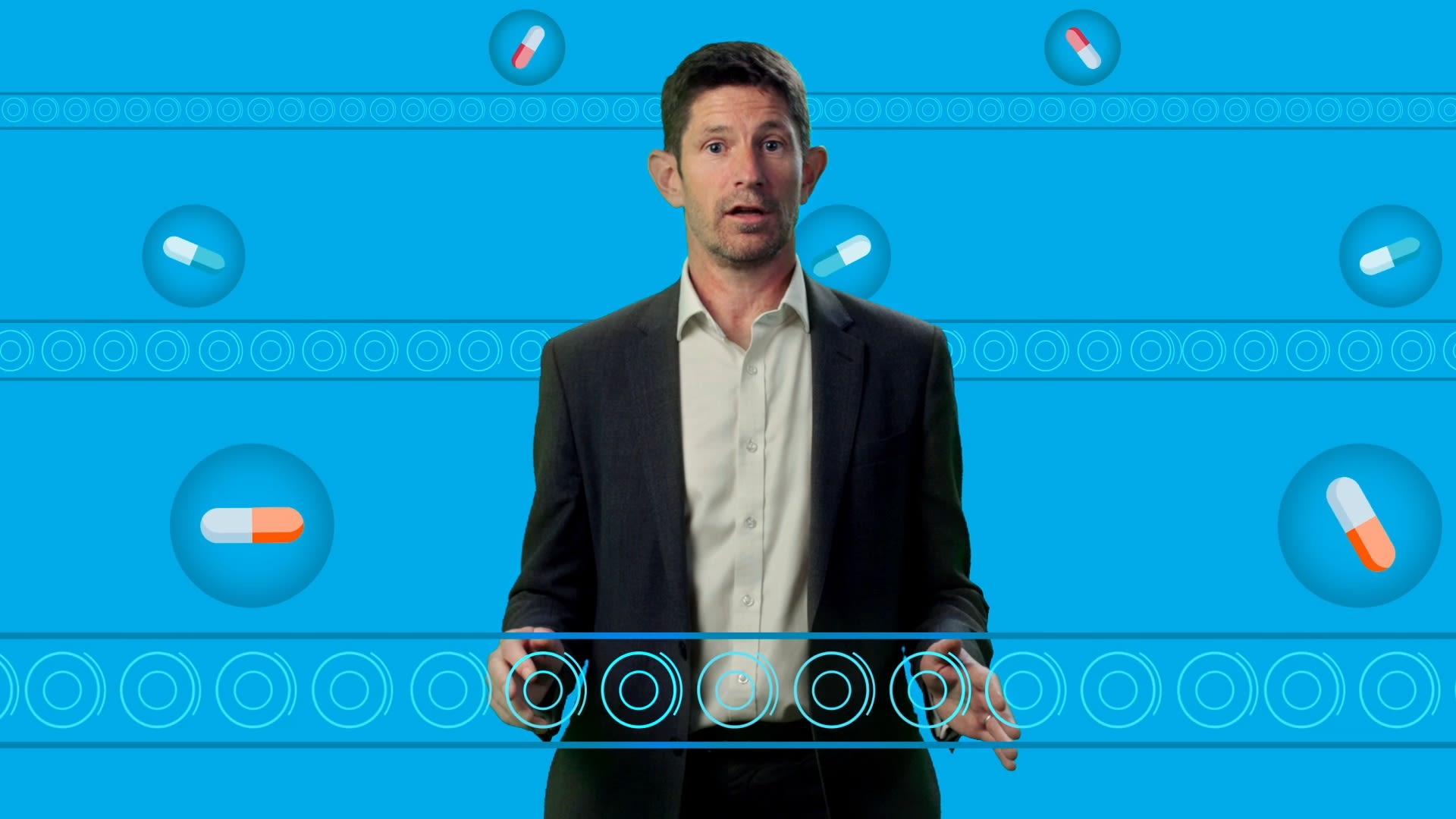 An image of Professor Tom Foltynie standing around illustrations of drugs on conveyer belts.