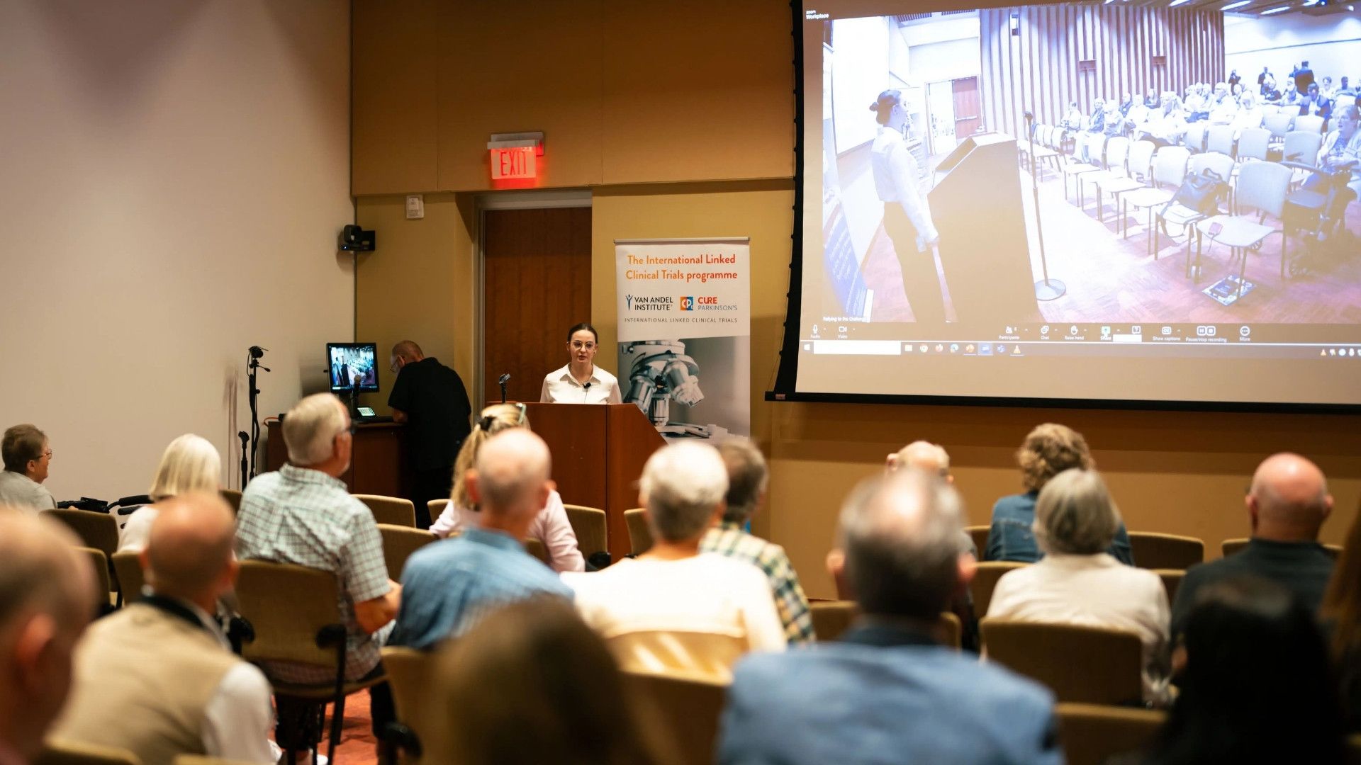 A researcher presents to an auditorium at our Rallying to the Challenge meeting.